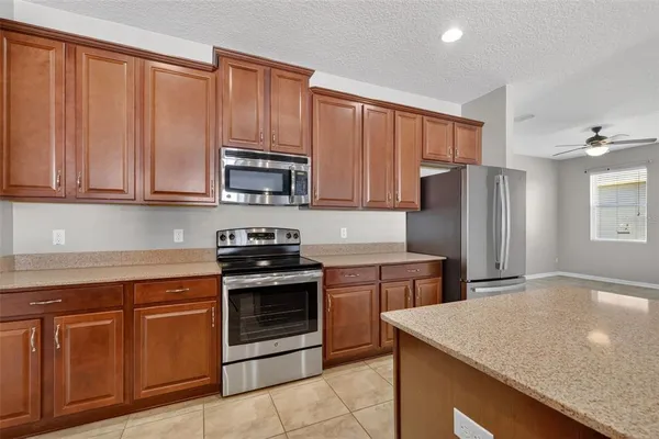 a kitchen with stainless steel appliances granite countertop a refrigerator stove top oven