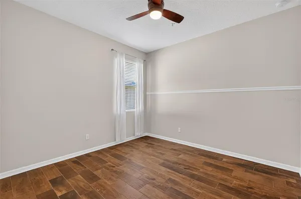 a view of an empty room with wooden floor