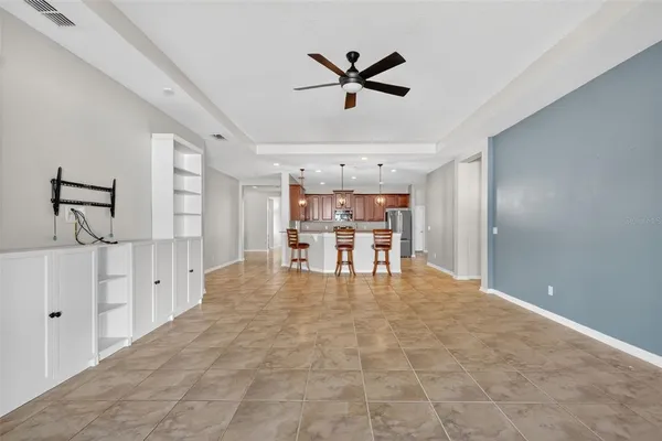 a view of a livingroom with a ceiling fan hardwood floor and a ceiling fan