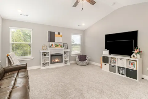 a living room with furniture a flat screen tv and a fireplace