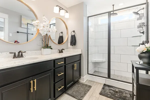 a bathroom with a double vanity sink mirror and shower