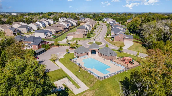 an aerial view of residential house with yard and swimming pool