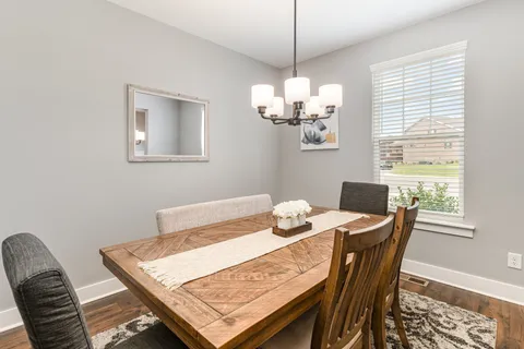 a view of a dining room with furniture a chandelier and wooden floor