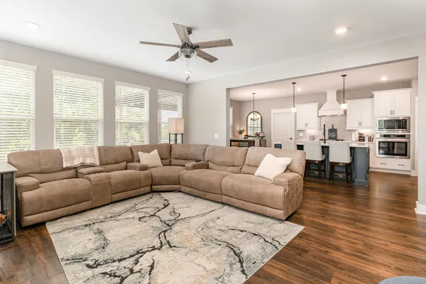 a living room with furniture and view of kitchen