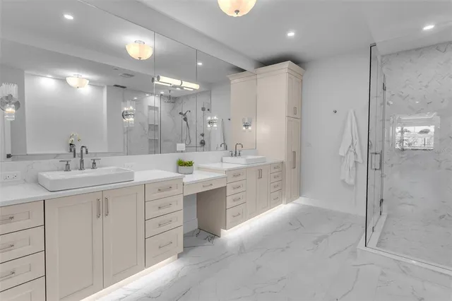 a bathroom with a double vanity sink mirror and shower