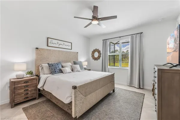 a bedroom with a bed a couch and a chandelier