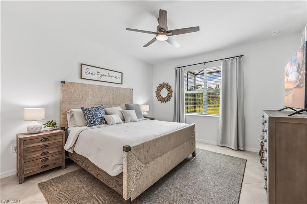 17716 Palmetto Pass Lane Babcock Ranch, FL 33982 - Photo 11 of 20 a bedroom with a bed a couch and a chandelier