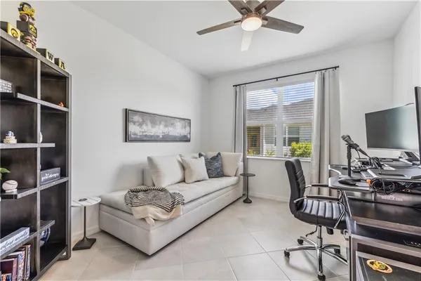 a living room with furniture a ceiling fan and a window