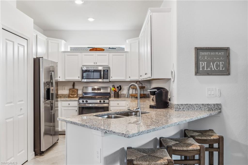 17716 Palmetto Pass Lane Babcock Ranch, FL 33982 - Photo 8 of 20 a kitchen with stainless steel appliances granite countertop a sink refrigerator and cabinets