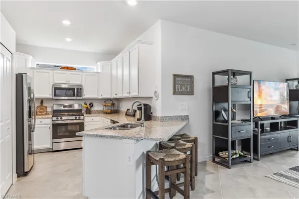 a kitchen with stainless steel appliances granite countertop a refrigerator stove microwave and sink