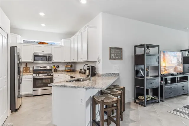 a kitchen with stainless steel appliances granite countertop a refrigerator stove microwave and sink