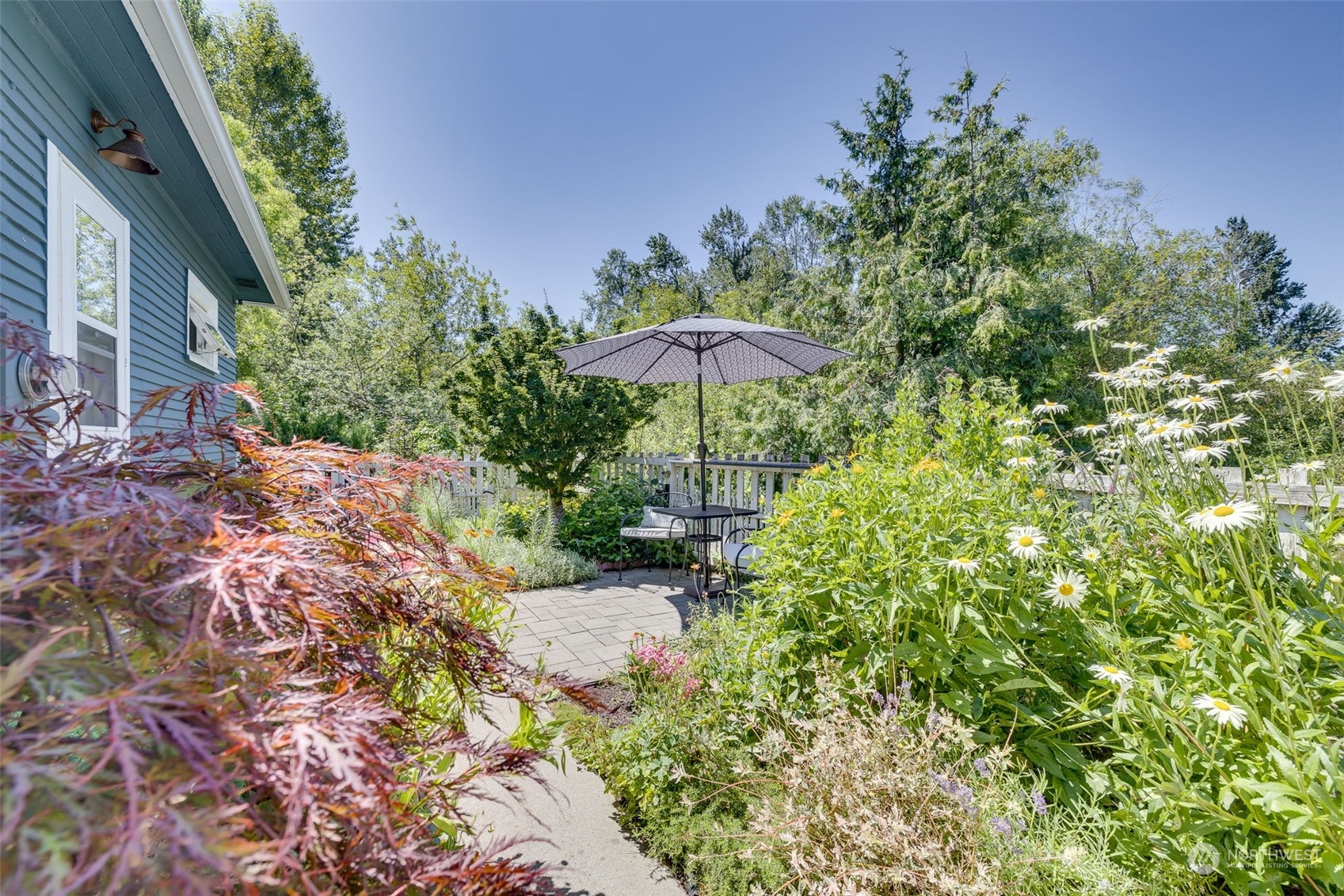 1232 Donovan Lane Everett, WA 98201 - Photo 23 of 34 a backyard of a house with table and chairs under an umbrella