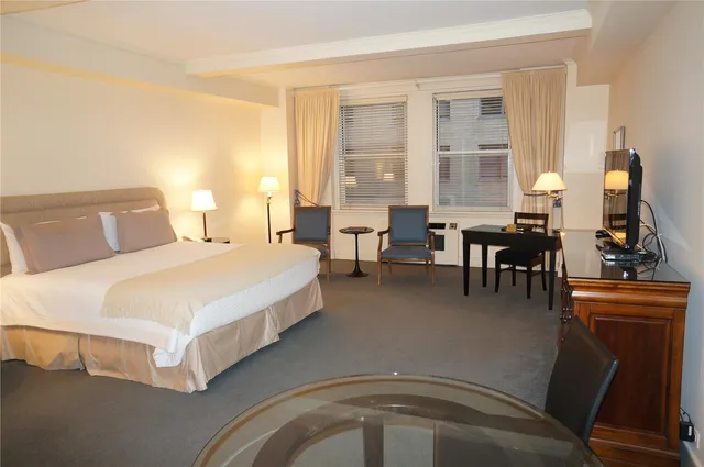 a spacious bedroom with a bed and wooden floor