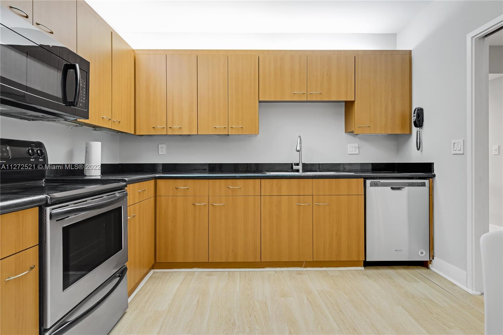 101 Crandon Boulevard, Unit 267 Key Biscayne, FL 33149 - Photo 12 of 57 a kitchen with wooden cabinets and a stove top oven