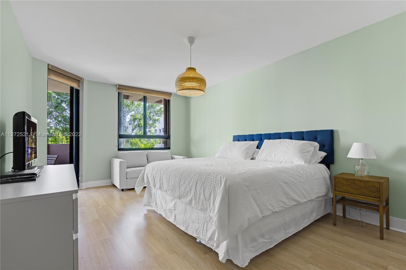 101 Crandon Boulevard, Unit 267 Key Biscayne, FL 33149 - Photo 16 of 57 a bedroom with a bed and a chandelier