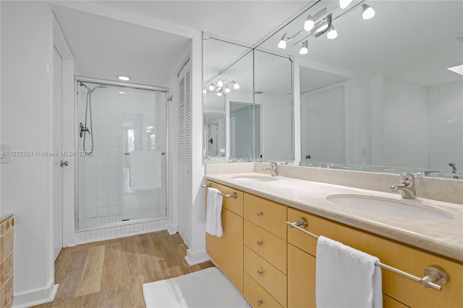 101 Crandon Boulevard, Unit 267 Key Biscayne, FL 33149 - Photo 19 of 57 a bathroom with double vanity sink and shower