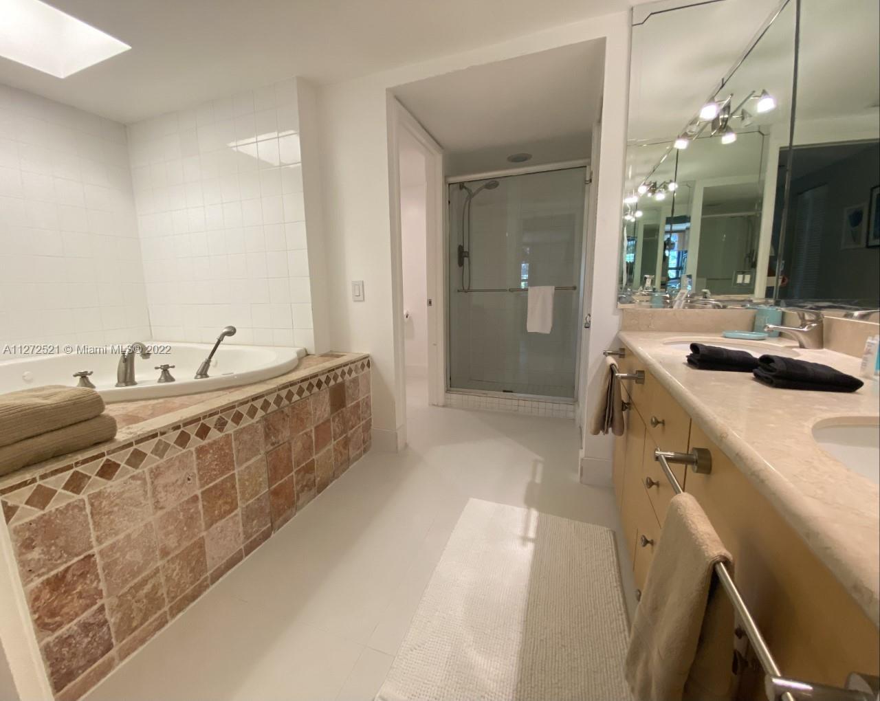 101 Crandon Boulevard, Unit 267 Key Biscayne, FL 33149 - Photo 22 of 57 a spacious bathroom with a double vanity sink and a mirror