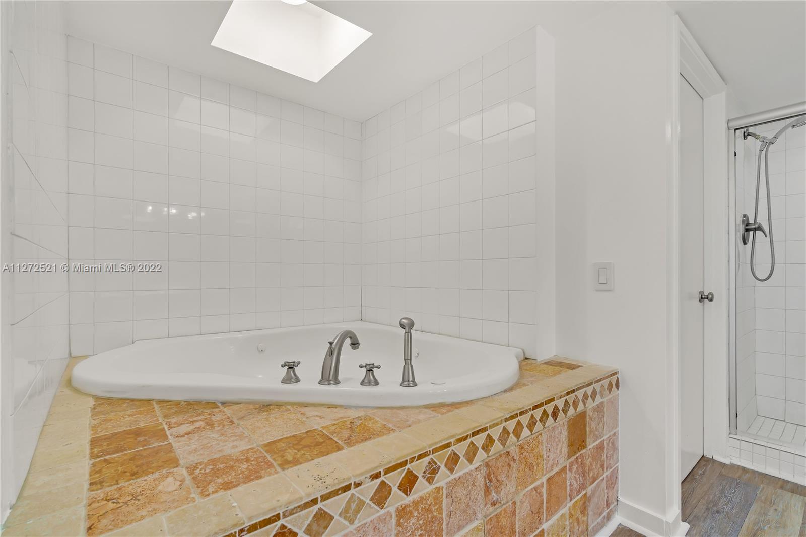 101 Crandon Boulevard, Unit 267 Key Biscayne, FL 33149 - Photo 23 of 57 a white bath tub sitting in a bathroom