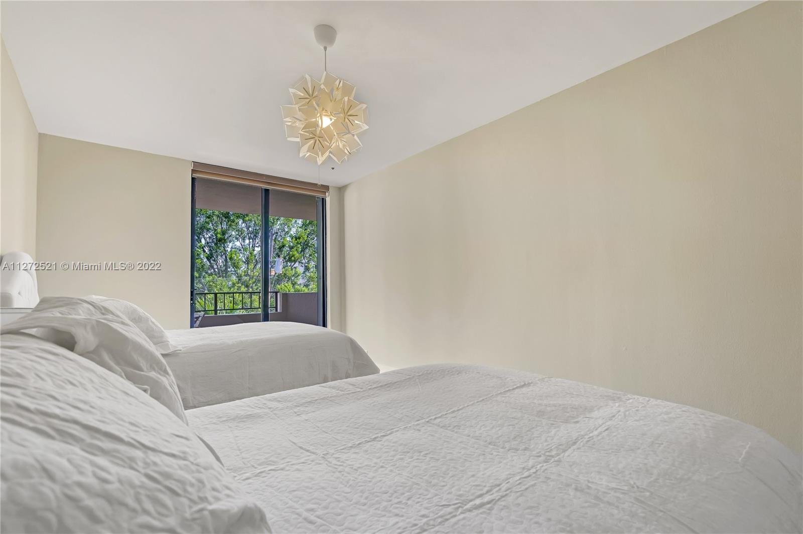 101 Crandon Boulevard, Unit 267 Key Biscayne, FL 33149 - Photo 26 of 57 a view of a bedroom with a bed and a chandelier
