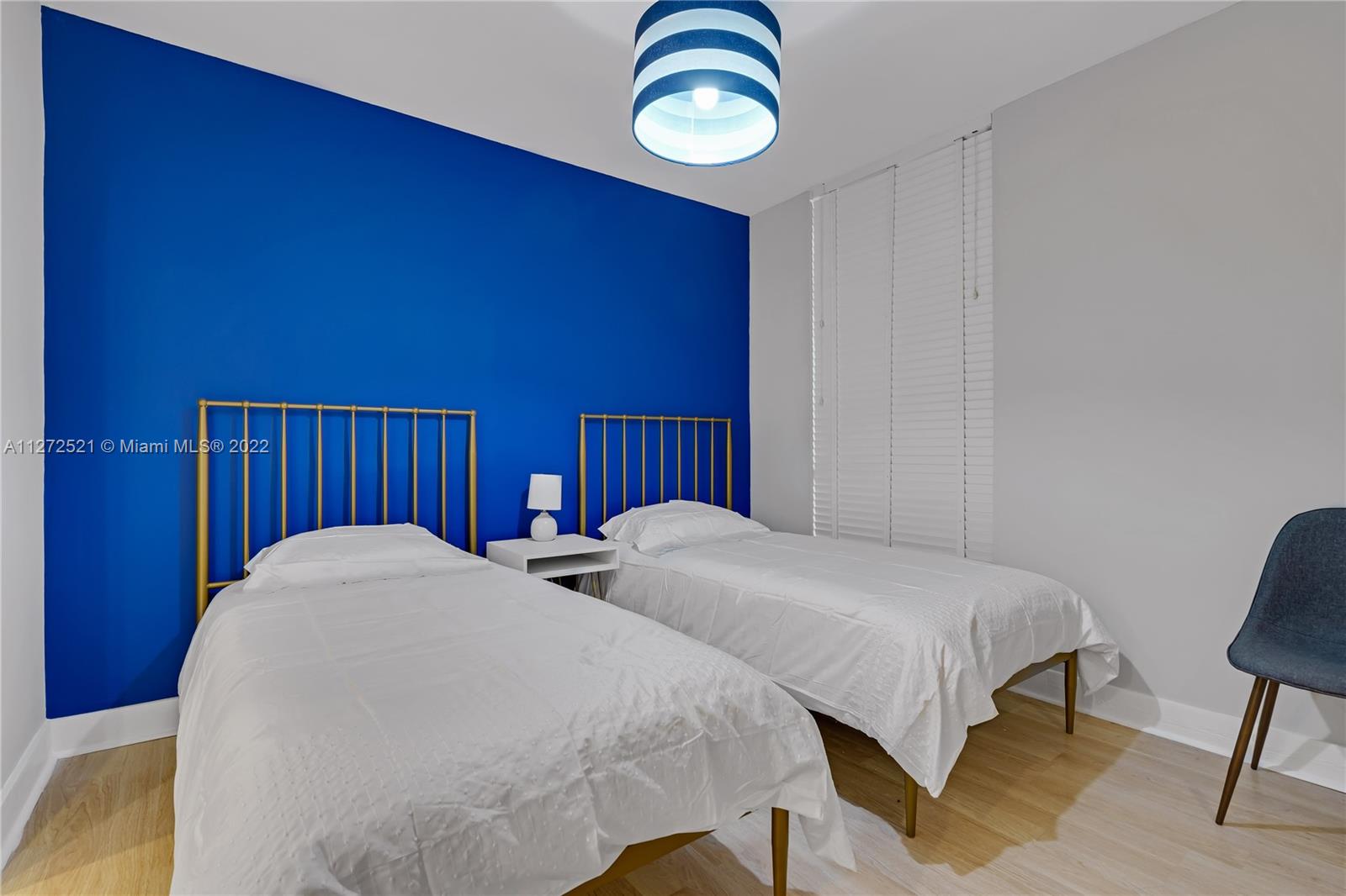 101 Crandon Boulevard, Unit 267 Key Biscayne, FL 33149 - Photo 34 of 57 a bedroom with two beds and a lamp