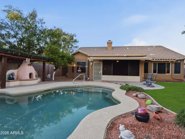 a view of house with swimming pool and outdoor seating