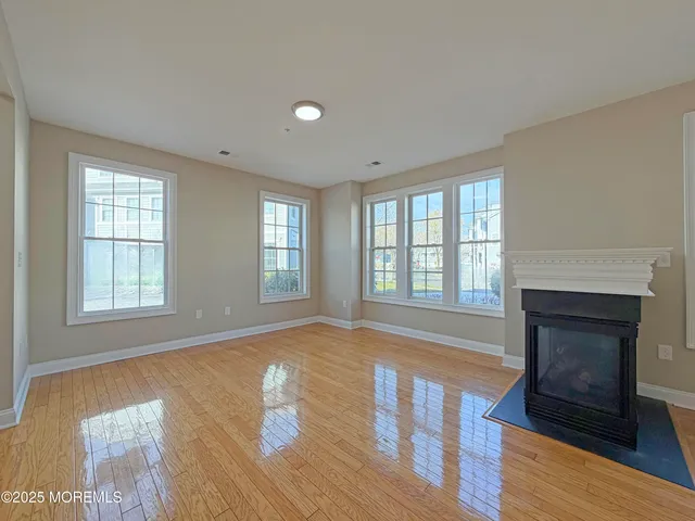 an empty room with windows and fireplace
