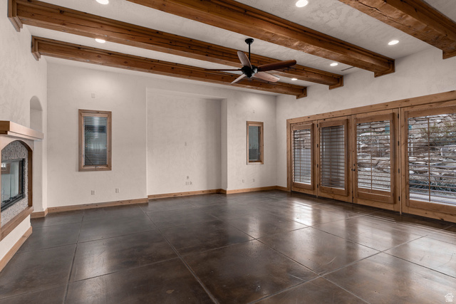 2464 East Granite Way St. George, UT 84790 - Photo 55 of 106 Unfurnished living room with beamed ceiling, ceiling fan, recessed lighting, and a glass covered fireplace