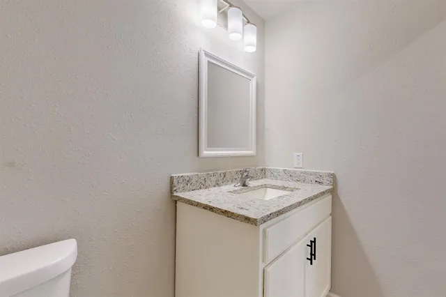 a kitchen with granite countertop a refrigerator a stove a sink a microwave and a refrigerator