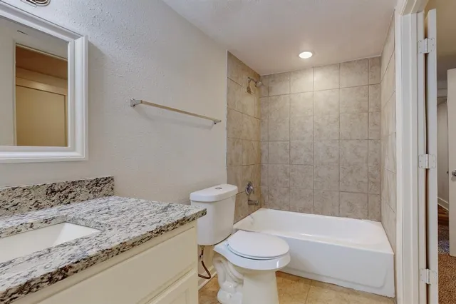 a bathroom with a granite countertop toilet and sink