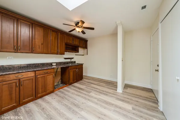 a kitchen with granite countertop wooden cabinets a stove top oven a sink and dishwasher