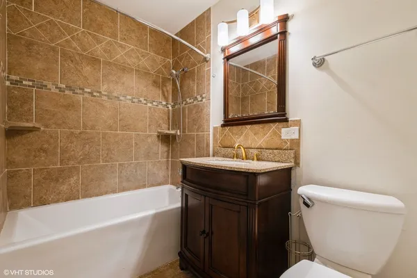 a bathroom with a sink toilet vanity and bathtub
