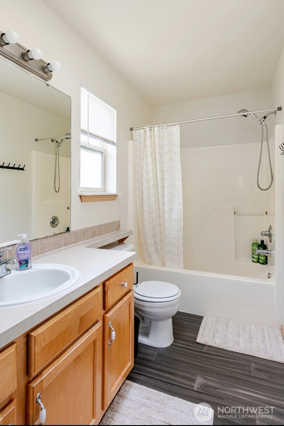 10047 17th Avenue Southwest Seattle, WA 98146 - Photo 15 of 27 a bathroom with a sink toilet a mirror and shower