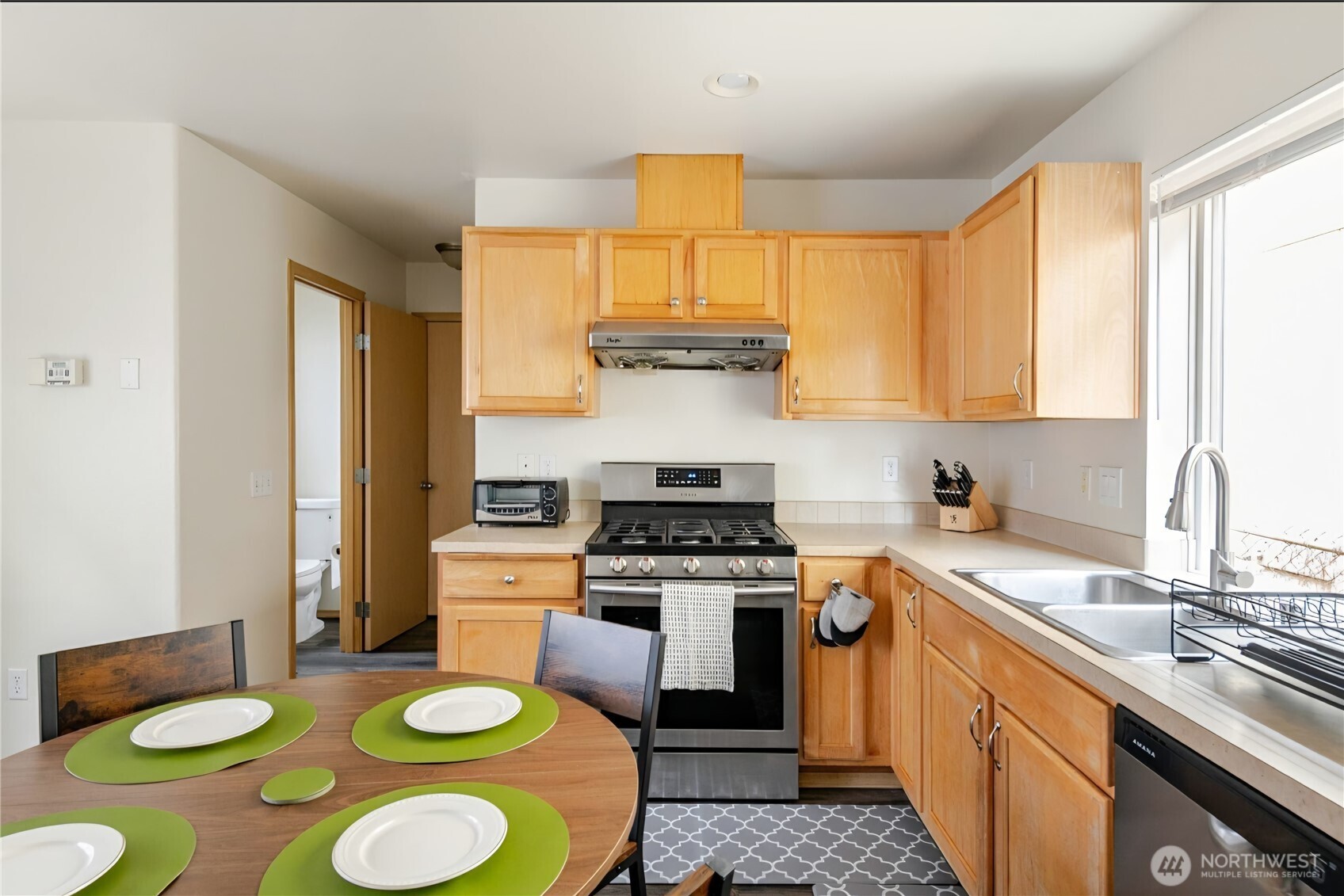 10047 17th Avenue Southwest Seattle, WA 98146 - Photo 8 of 27 a kitchen with a stove a sink and a granite counter tops