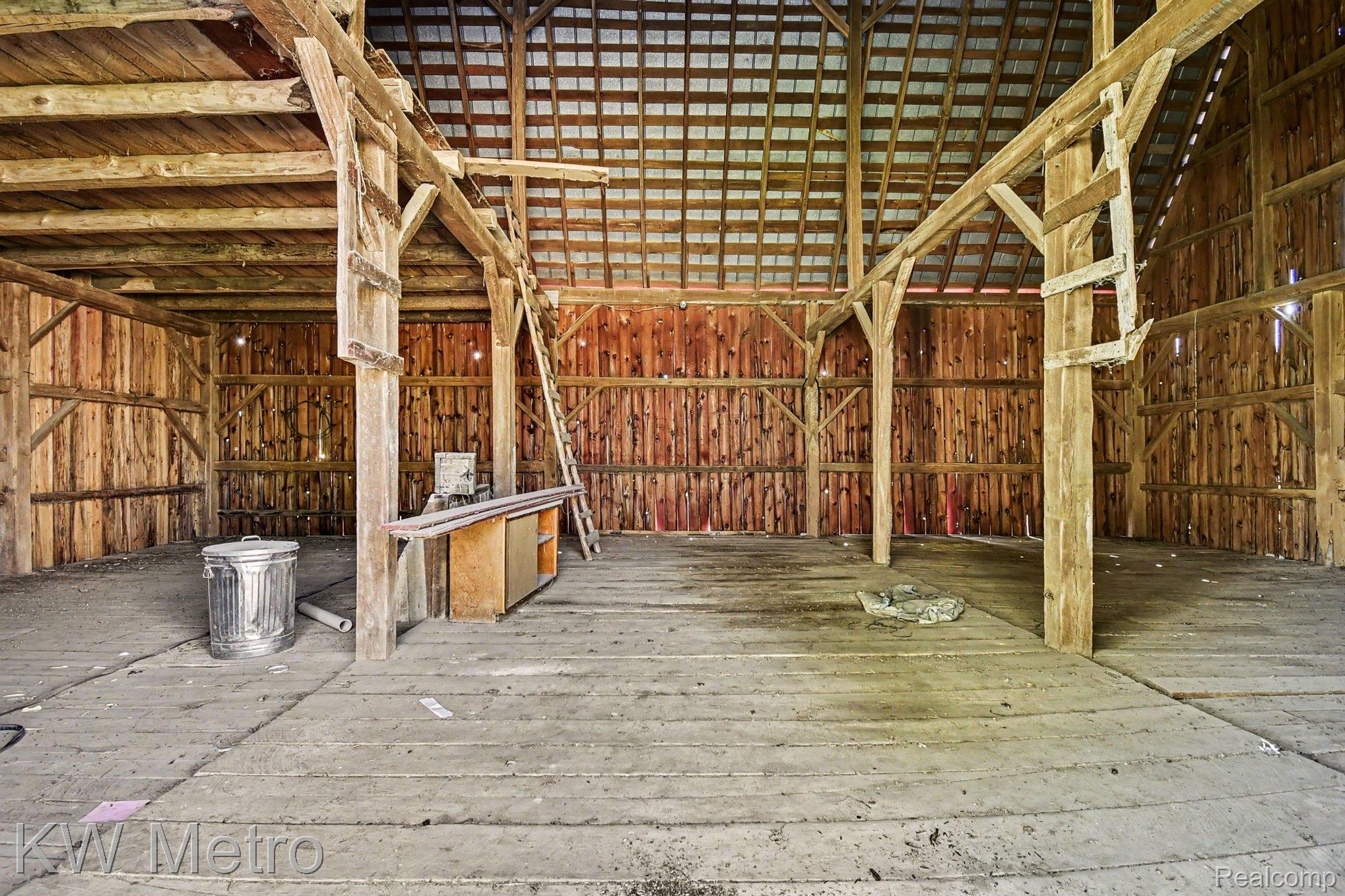2682 East Haskell Lake Road Harrison, MI 48625 - Photo 42 of 61 Spacious barn interior featuring exposed wooden beams and vertical wood plank walls