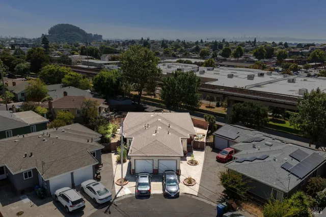 an aerial view of a house with a garden and mountain view in back