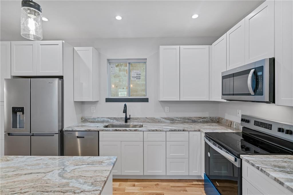 1102 Spring Garden Avenue Pittsburgh, PA 15212 - Photo 8 of 25 a kitchen with a sink stainless steel appliances and white cabinets