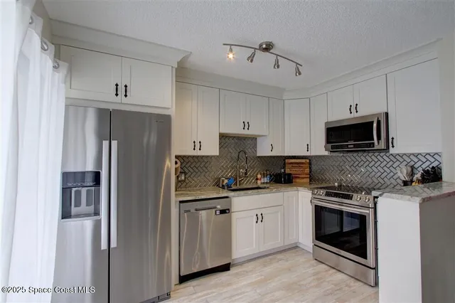 a kitchen with stainless steel appliances a stove sink and microwave