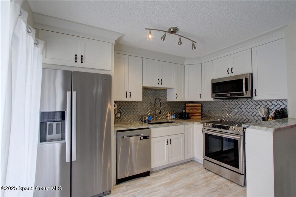 1717 Patty Circle Northeast Palm Bay, FL 32905 - Photo 11 of 35 a kitchen with stainless steel appliances a stove sink and microwave