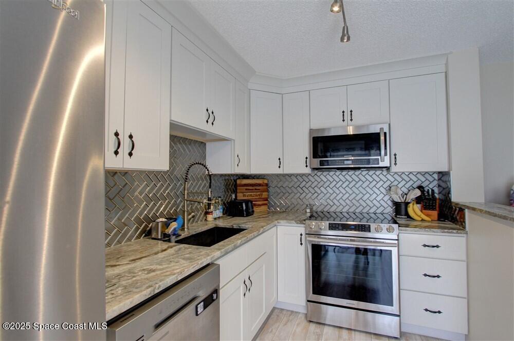 1717 Patty Circle Northeast Palm Bay, FL 32905 - Photo 12 of 35 a kitchen with white cabinets and appliances