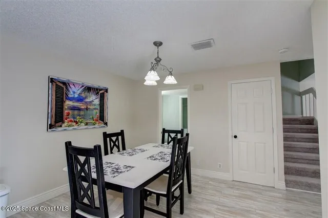 a view of a dining room with furniture wooden floor and a chandelier