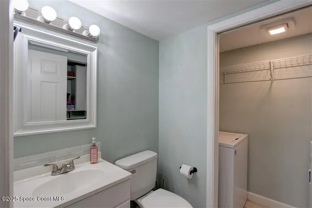 a bathroom with a sink vanity mirror and toilet