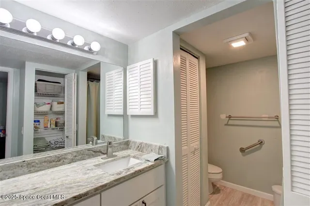 a bathroom with a granite countertop sink toilet and shower