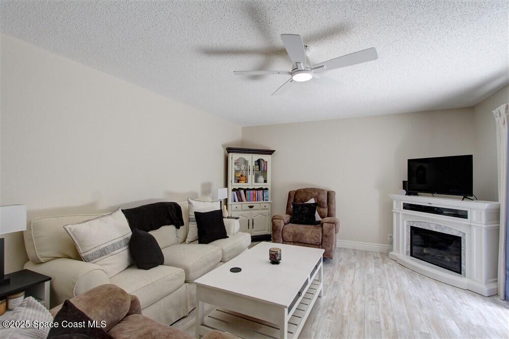 1717 Patty Circle Northeast Palm Bay, FL 32905 - Photo 8 of 35 a living room with furniture a flat screen tv and a fireplace