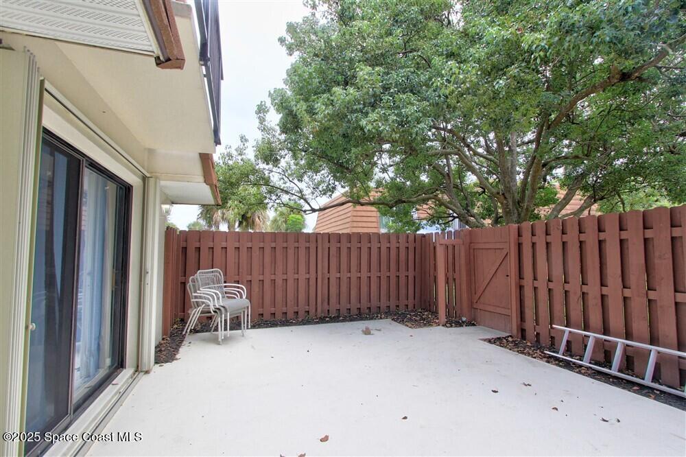1717 Patty Circle Northeast Palm Bay, FL 32905 - Photo 9 of 35 a view of a backyard with wooden fence and a large tree