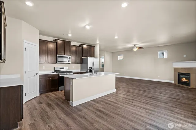 a kitchen with stainless steel appliances kitchen island granite countertop a stove top oven a sink and a microwave