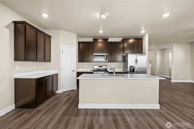 a kitchen with stainless steel appliances a stove top oven a sink and a refrigerator