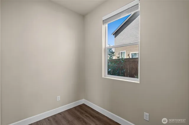 a view of a small space with wooden floor and a window