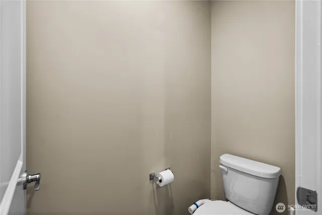 a white toilet sitting next to a white wall
