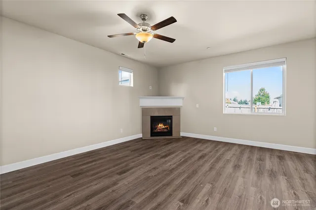 a view of an empty room with wooden floor and a fireplace