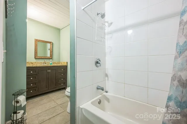 a bathroom with a tub sink and mirror